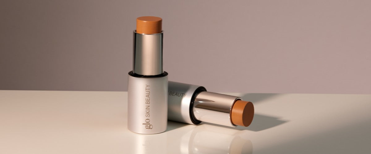 Two cream contour sticks in warm tan with visible 'glo skin beauty' branding.