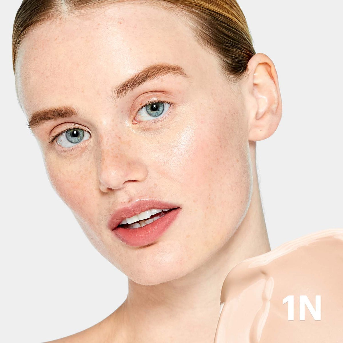 Close-up of a woman with clear skin and a beige tint swatch labeled '1N' for C-Shield Anti-Pollution Moisture Tint SPF 30