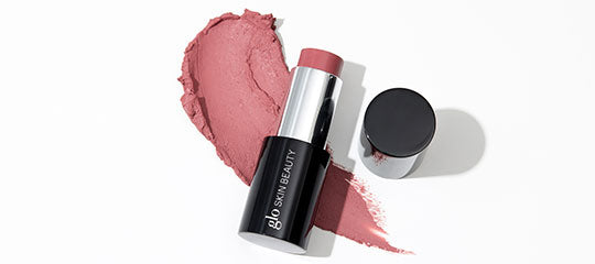 Muted rose cream blush stick bullet and smudged swatch, 'glo SKIN BEAUTY' branding on black tube