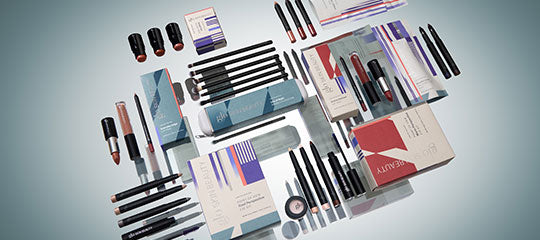 Assorted makeup products and tools arranged flat: lipsticks, eyeliners, pencils, compacts, and boxed cosmetic packaging.