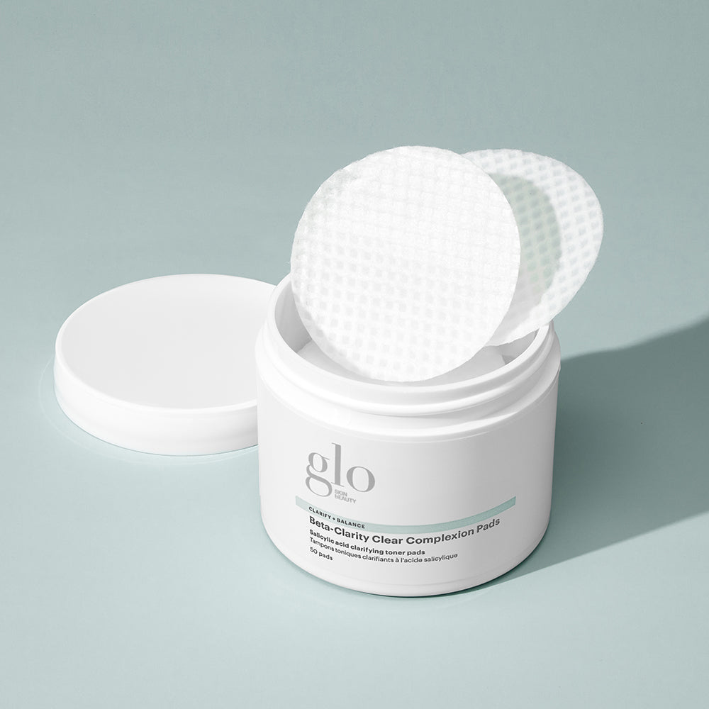 Open jar of glo labeled 'Beta-Clarity Clear Complexion Pads, 50 pads' with textured round pads