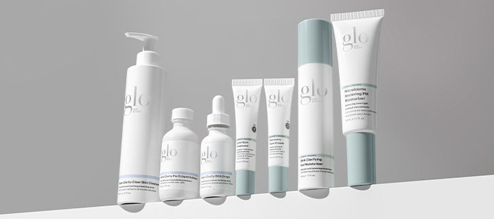 glo skincare product lineup: seven white-and-mint bottles and tubes on an angled shelf
