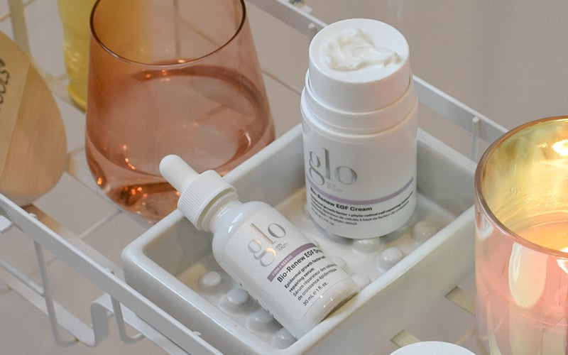 Glo skincare products on a tray: jar labeled "glo Bio‑Renew EGF Cream" and dropper bottle labeled "Bio‑Renew EGF Serum".