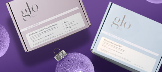 Two pastel 'glo' skincare boxes with purple glitter ornaments on a purple background
