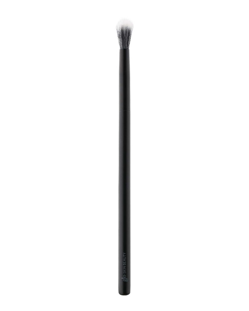 Slim black eye-blending brush with fluffy white-tipped bristles; glo SKIN BEAUTY printed on handle