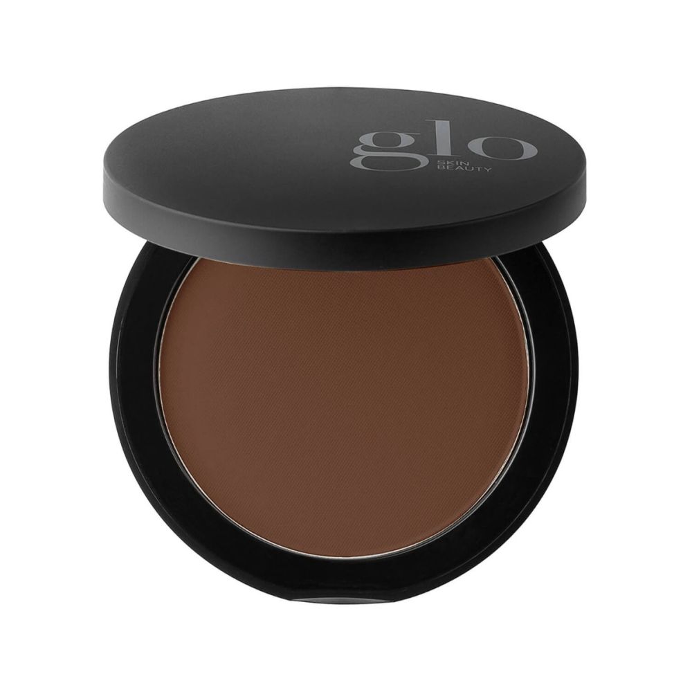 Compact black-lidded bronzer pan with matte dark-brown powder; lid labeled glo SKIN BEAUTY.