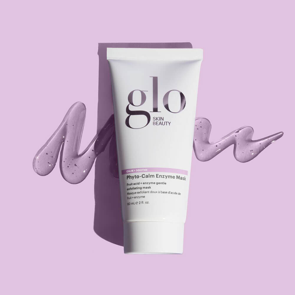 Tube of glo SKIN BEAUTY Phyto-Calm Enzyme Mask with 'CALM + SOOTHE' label, purple cream swirls on lavender background.