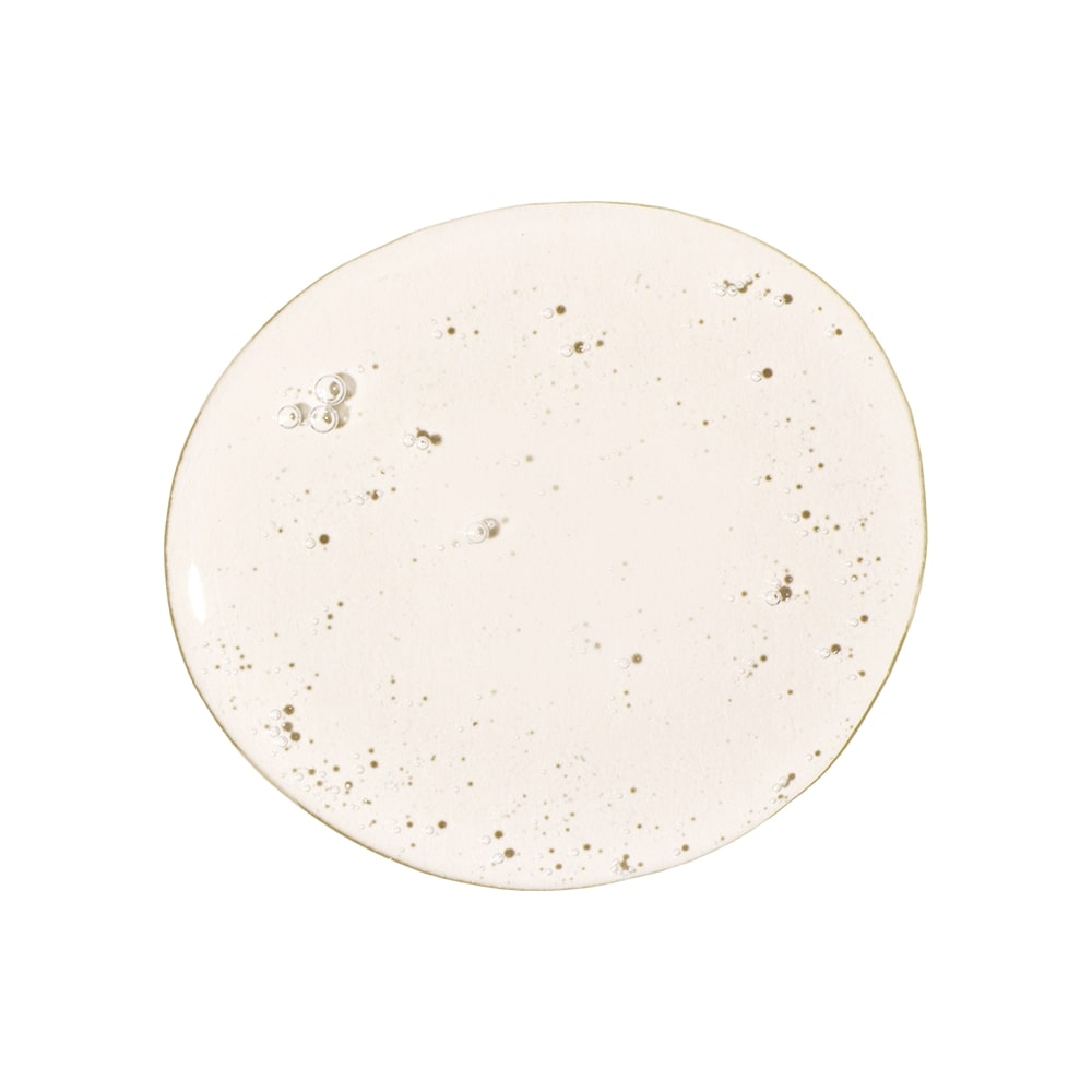 Beige translucent serum droplet with small air bubbles on white background