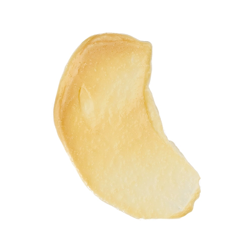 Pale crescent-shaped cashew kernel on a white background.