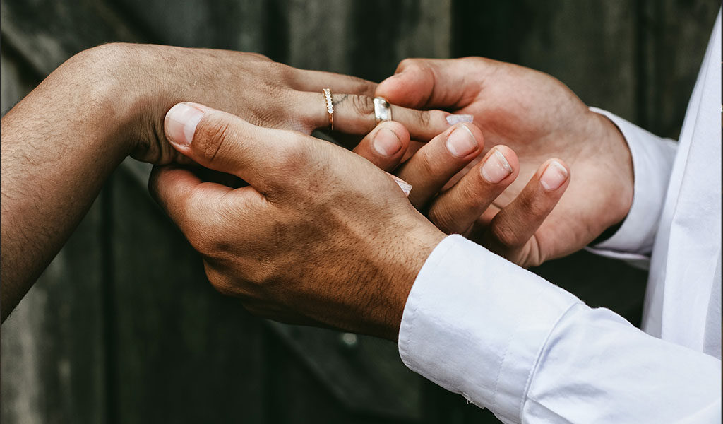 Groom putting on wedding ring