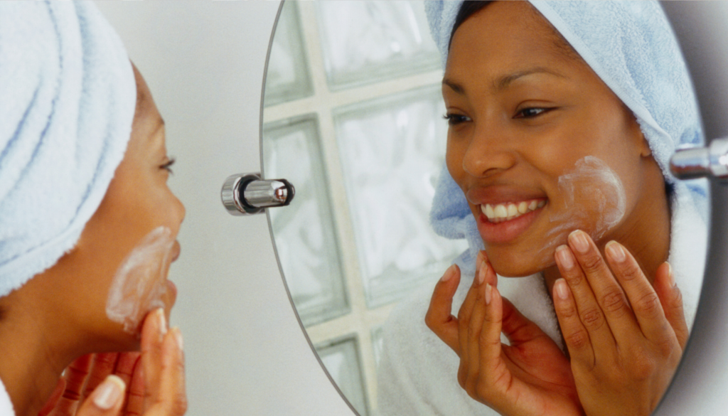 woman looking into mirror cleansing skin