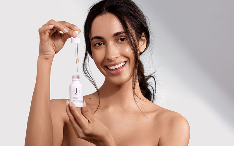 woman holding glo skin beauty serum