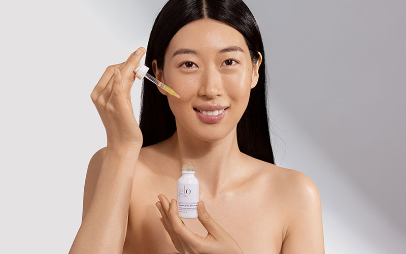 woman holding glo beauty acne product