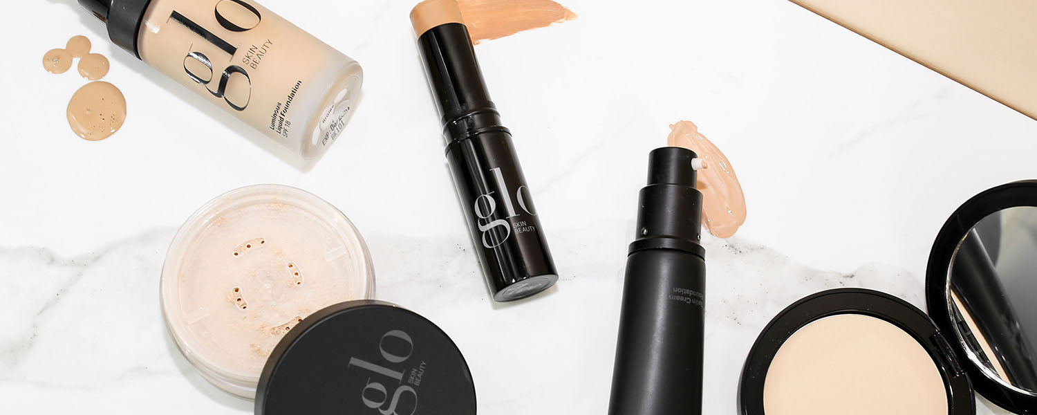 Assorted glo SKIN BEAUTY mineral foundations and powders on white marble surface