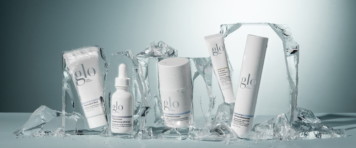 Front view of Glo Skin Beauty skincare bottles and tubes showcasing white minimalist packaging with ice blocks