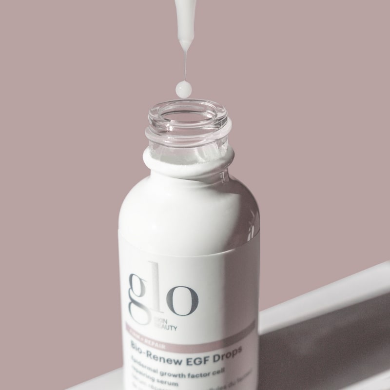 Dropper releasing a droplet above an open bottle labeled glo skin beauty — Bio-Renew EGF Drops.
