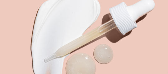 Dropper applying clear serum beside cream swatch and two gel droplets on pink-peach background.