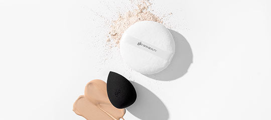Makeup sponge, powder puff labeled glo skin beauty, and liquid foundation swatch on white background