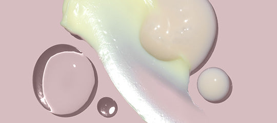 Abstract pastel cosmetic swatches and droplets on a pink background, close-up texture study.