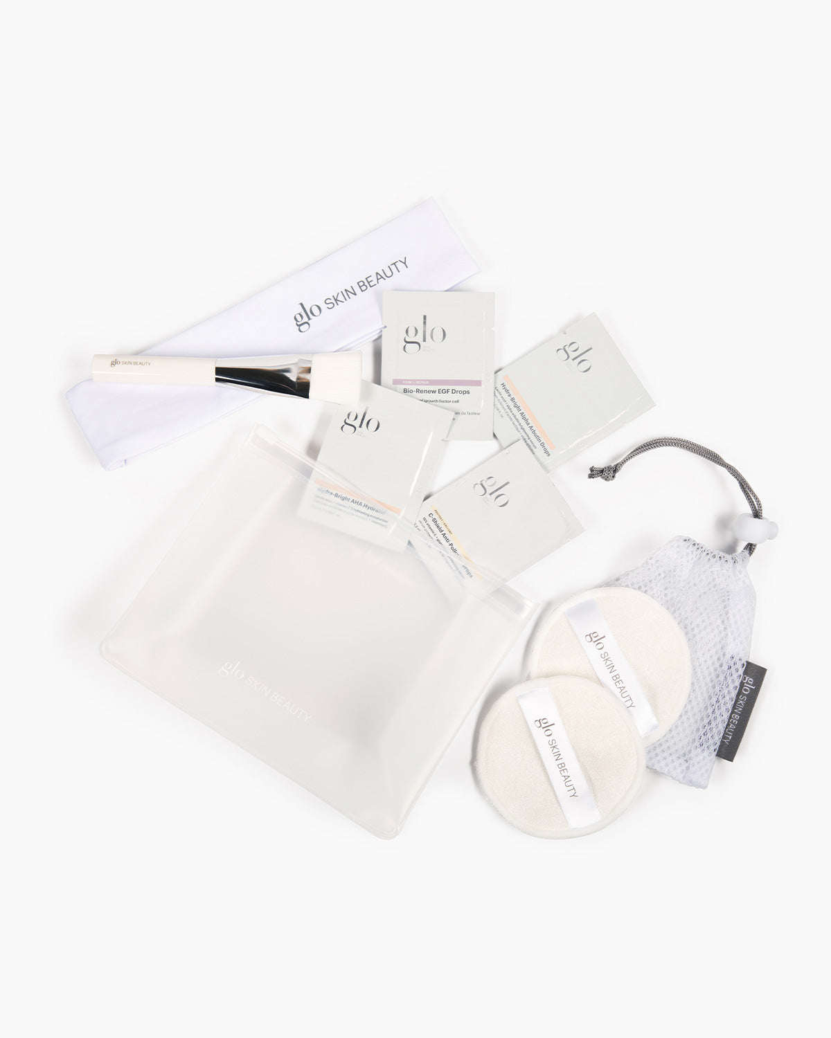 glo SKIN BEAUTY travel kit with brush, Bio-Renew EGF Drops sample sachet, clear zipper pouch and two cleansing pads