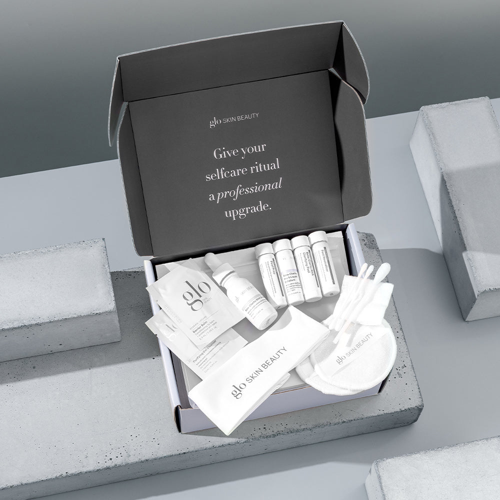 Open glo SKIN BEAUTY kit with sachets, vials and applicators; lid reads 'Give your selfcare ritual a professional upgrade.'