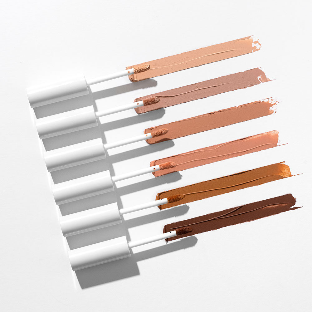 Six white applicators with six horizontal neutral eye-base swatches, from light beige to deep brown.