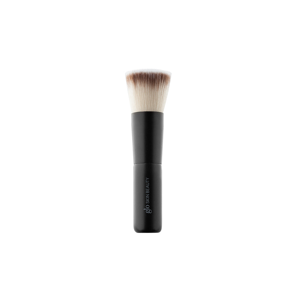 Front view of mini flat-top kabuki brush showcasing dense flat top bristles and short black handle on white background