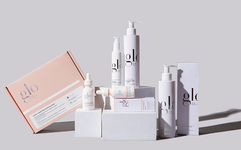 glo skin beauty product lineup: bottles, dropper serum, and boxed skincare set arranged on blocks