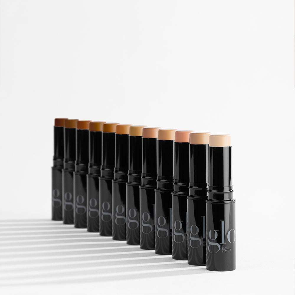 Row of HD mineral foundation sticks in varying shades, black tubes labeled glo skin beauty