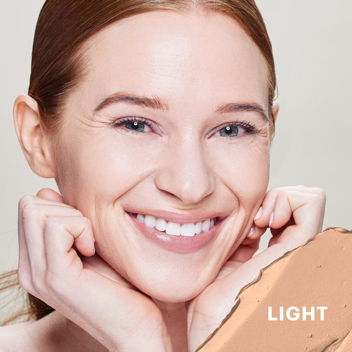 Smiling woman with light shade swatch labeled LIGHT for oil-free tinted primer SPF 30