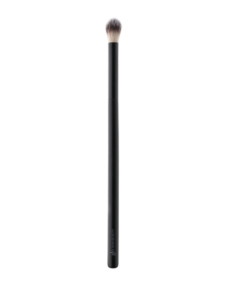 Makeup brush with black handle and fluffy bristles, brand name 'glo SKIN BEAUTY' visible on handle