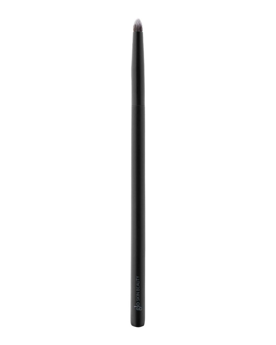 Small rounded-tipped black makeup brush with 'glo SKIN BEAUTY' printed on the handle