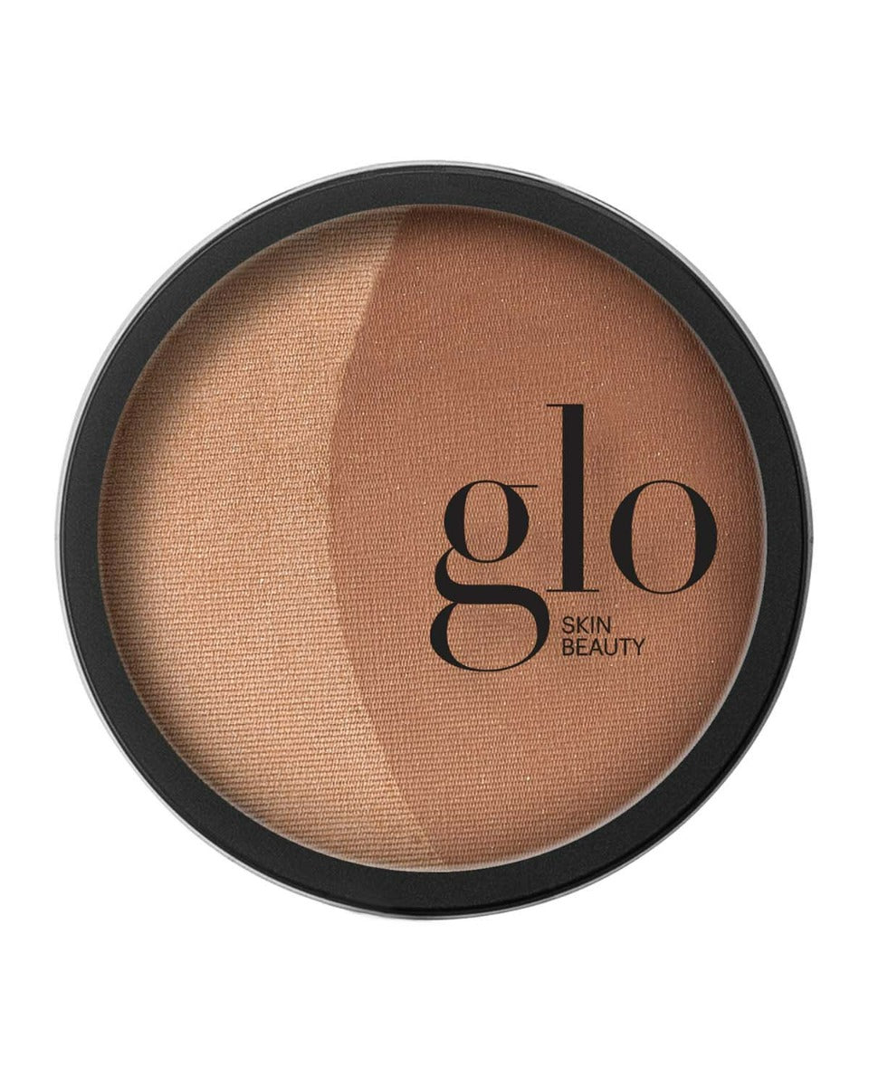 Round compact with two shades of bronzer and text 'glo SKIN BEAUTY'