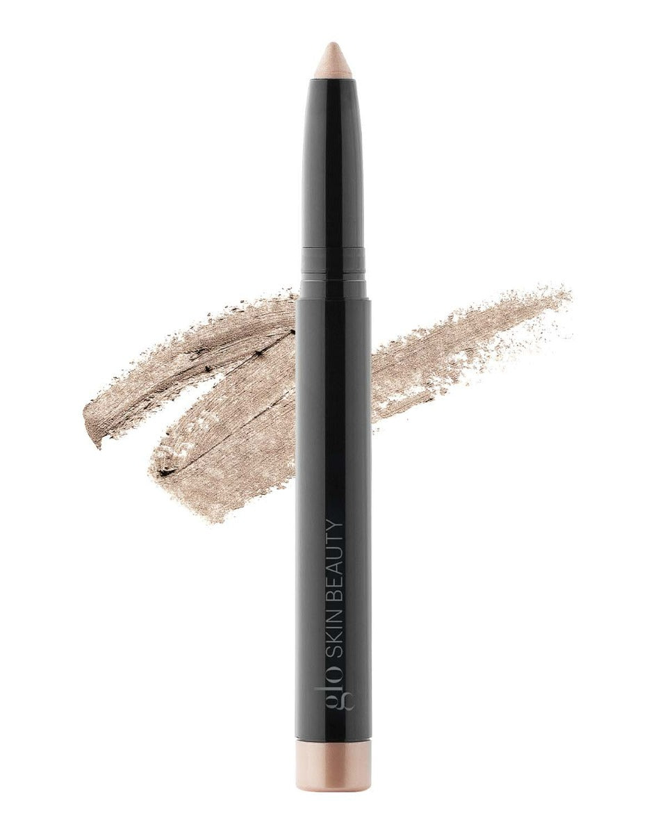 Champagne beige cream eyeshadow stick with swatch behind, branded glo SKIN BEAUTY.