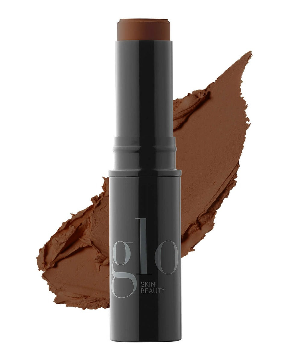 glo SKIN BEAUTY HD mineral foundation stick, deep brown shade with smeared foundation swatch behind