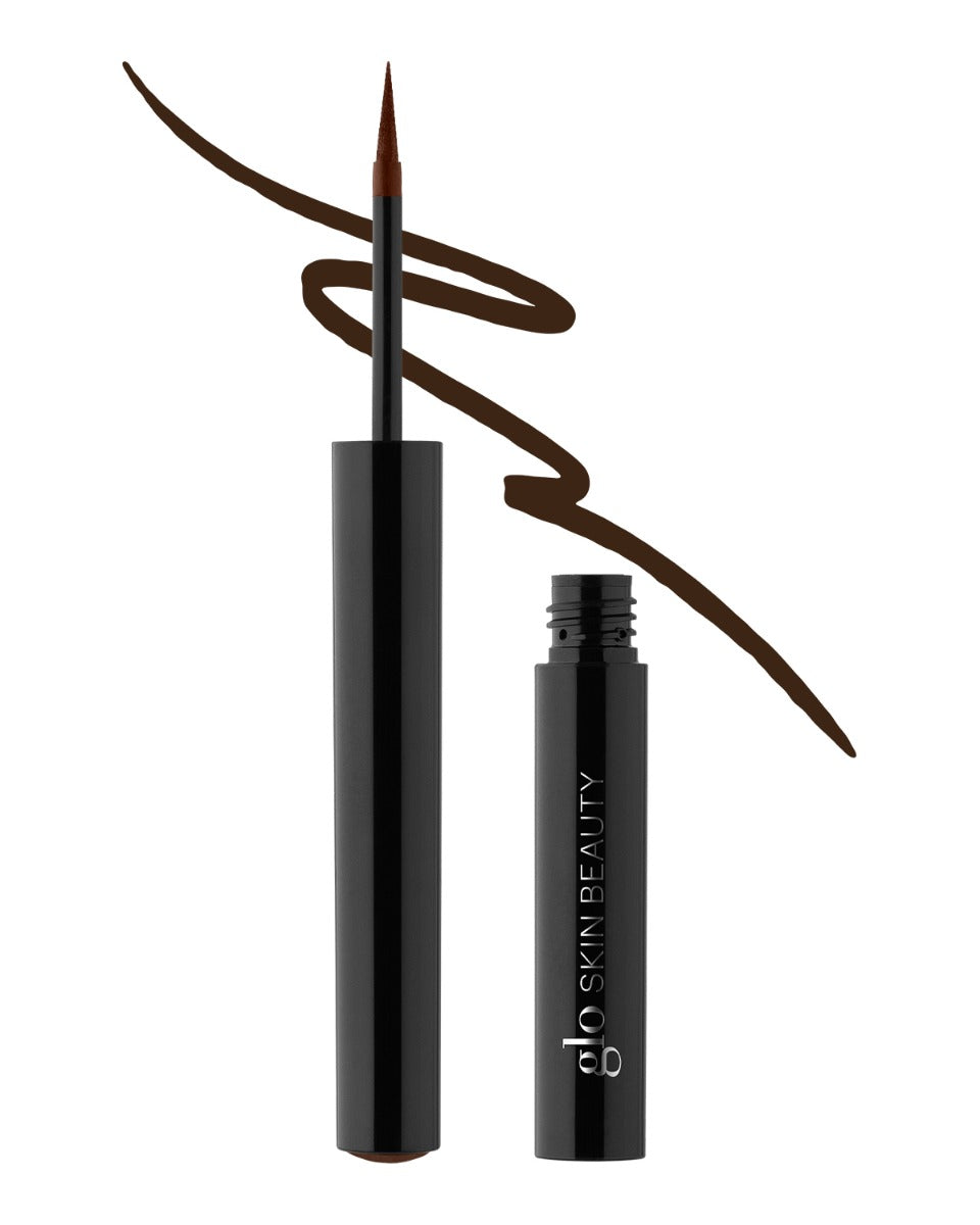 Liquid eyeliner pen and open tube with glo SKIN BEAUTY branding and dark brown swatch stroke