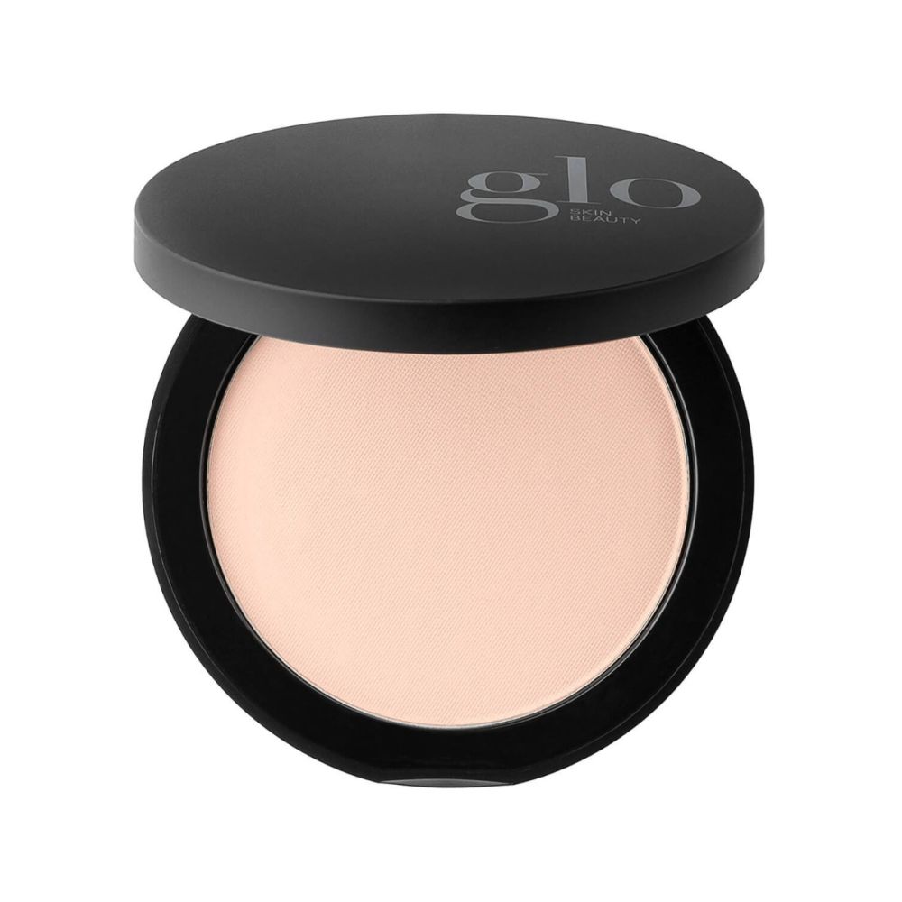 Top-down view of Pressed Base compact showing light beige pressed powder in black case with Glo logo on white background