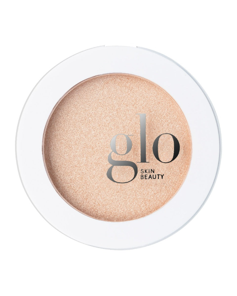 Round compact champagne highlighter with glo SKIN BEAUTY logo on white rimmed clear lid