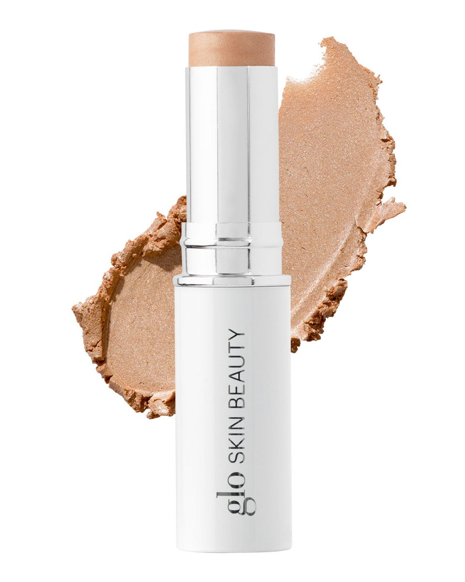 Highlighter stick with champagne shimmer swatch, tube labeled glo SKIN BEAUTY