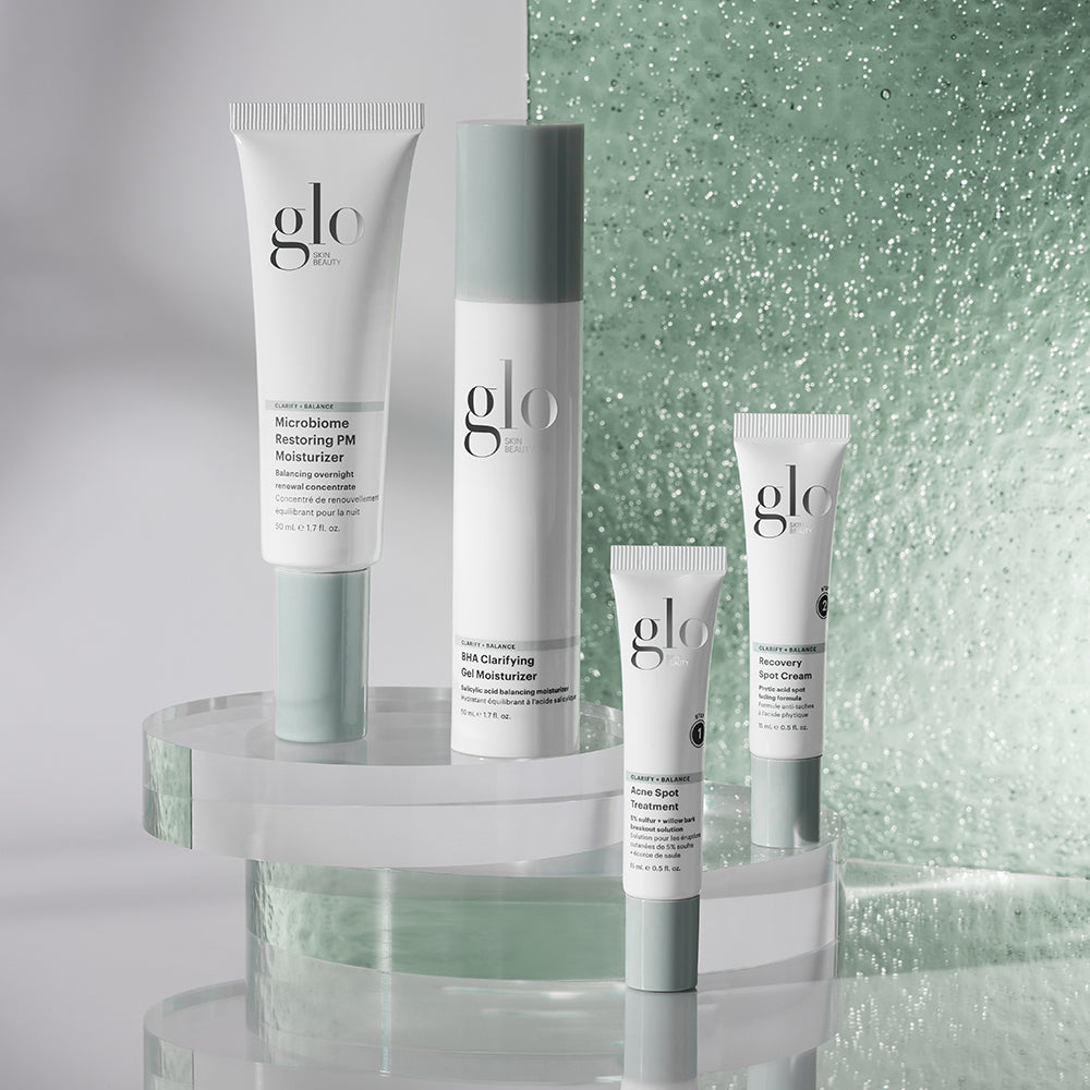 Glo Skin Beauty products: Microbiome Restoring PM Moisturizer; BHA Clarifying Gel Moisturizer; Acne Spot Treatment; Recovery Spot Cream on glass stands