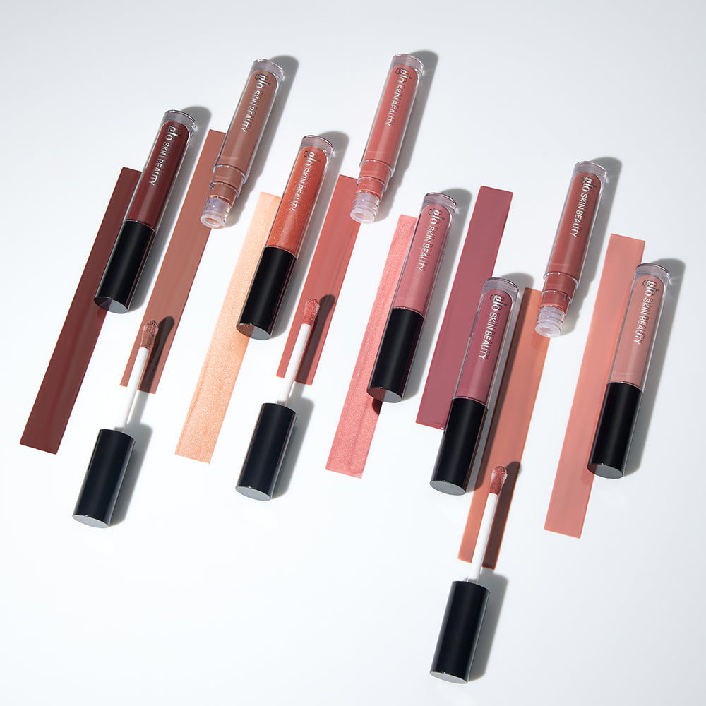 Assorted nude and pink liquid lipsticks with doe-foot applicators and swatches; tubes labeled glo SKIN BEAUTY