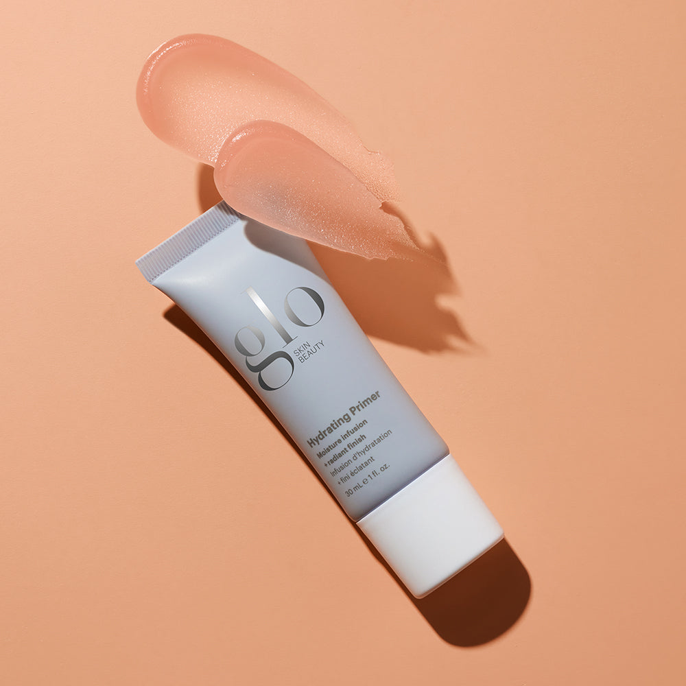 glo SKIN BEAUTY Hydrating Primer tube with peach primer swatch on peach background.