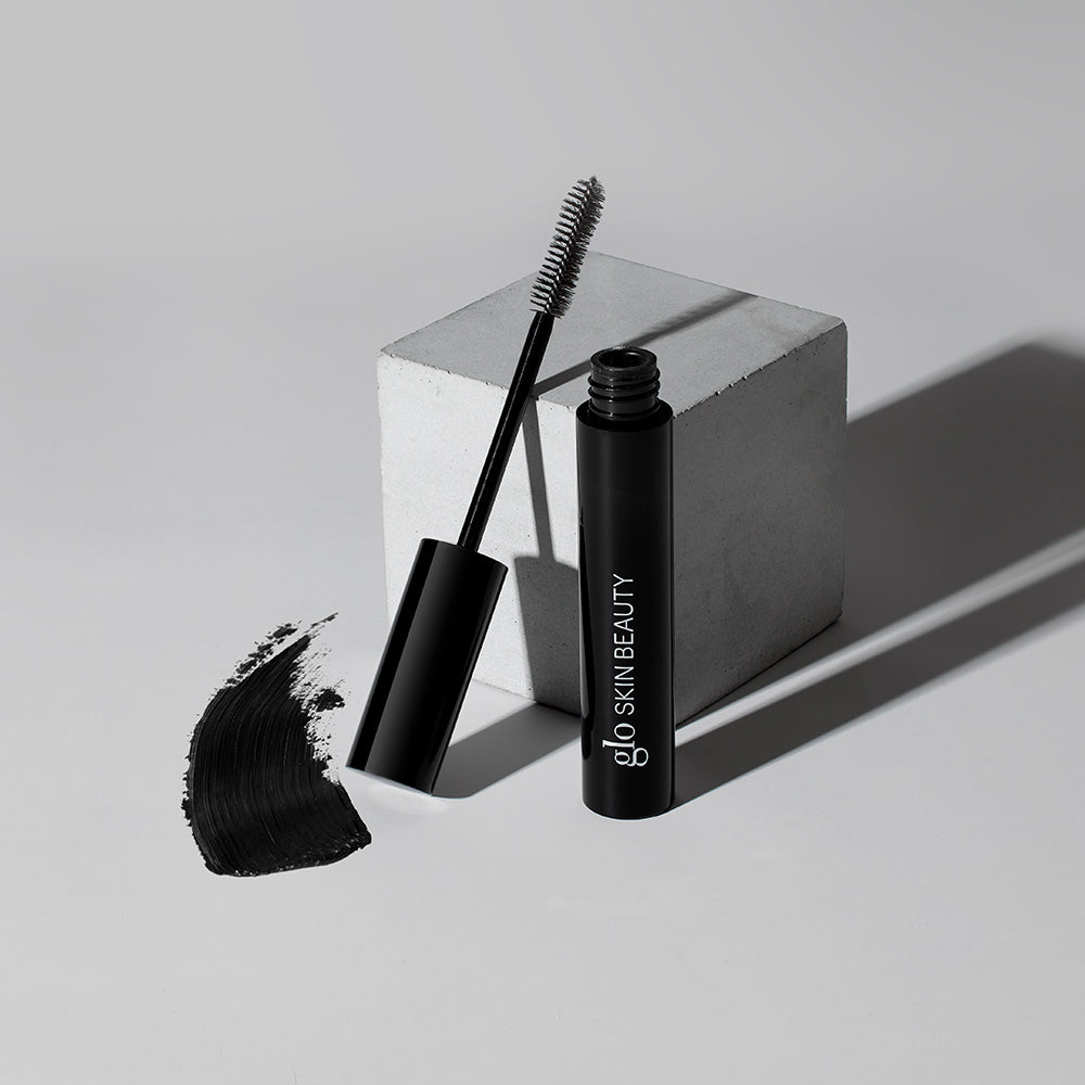Mascara tube and wand with black swatch; 'glo SKIN BEAUTY' printed on tube