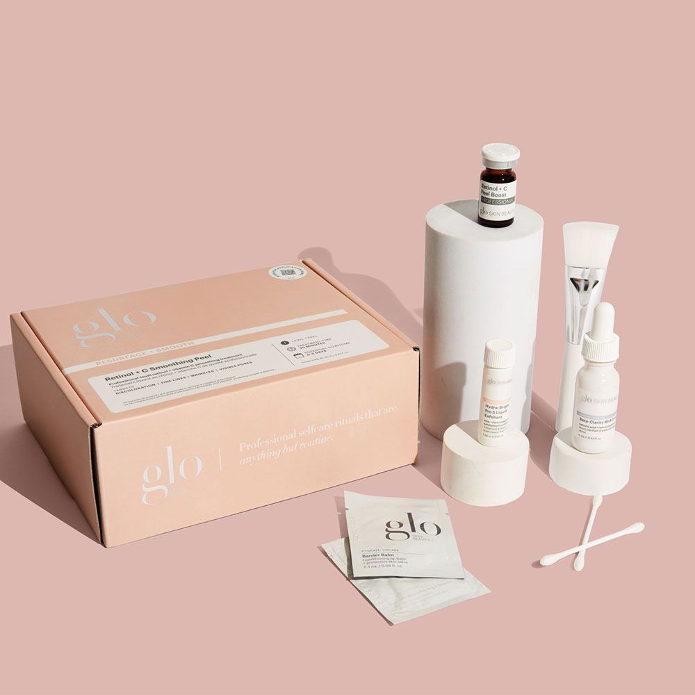 glo skincare kit with box labeled 'Retinol + C Smoothing Peel', vials, dropper, brush, cotton swabs and 'Barrier Balm' packets