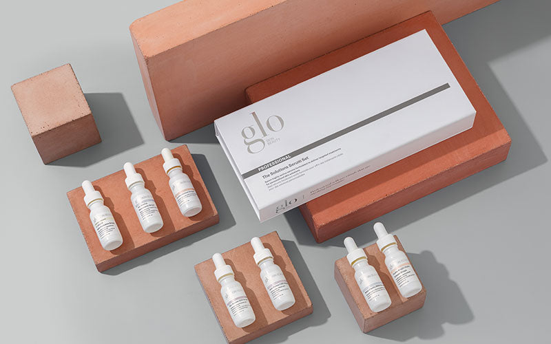 glo PROFESSIONAL Solution Serum set with six dropper bottles and white box on terracotta blocks