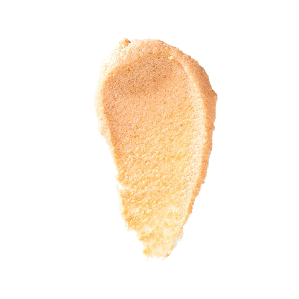 beige Pumpkin Enzyme Scrub smear with textured surface on white background