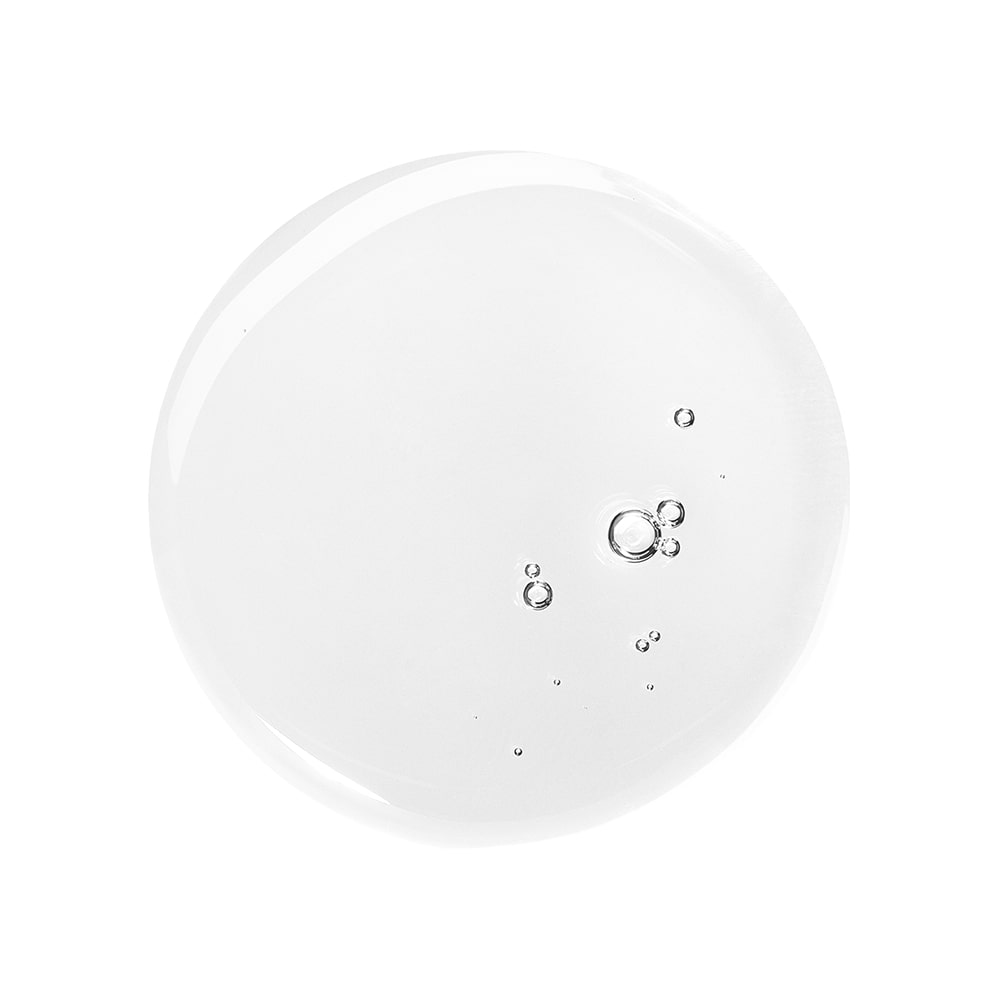 Clear circular serum droplet with several small air bubbles on a white background