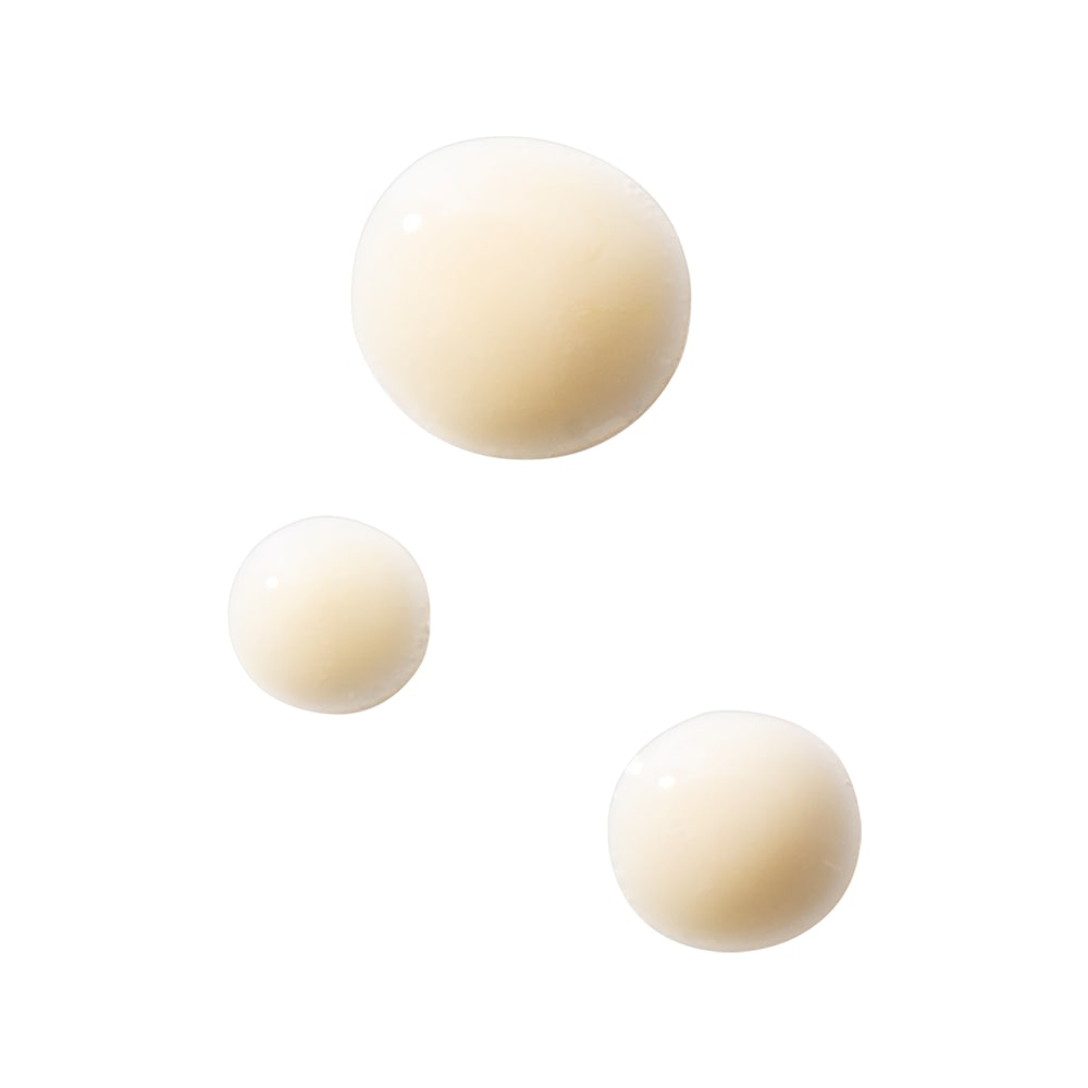 Three beige cream droplets showing cleanser texture